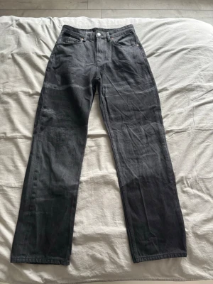 Svarta raka jeans med mönster - Snygga svarta jeans med rak passform och ett stilrent svart mönster. Klassisk femficksmodell med knapp och dragkedja framtill. Jeansen är tillverkade i denim och har en stilren look som passar till det mesta.