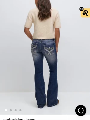 Blå bootcut jeans med broderade fickor - Säljer nu mina jeans från Gina tricot som jag köpte förra året, använda 2 gånger. Kommer inte till användning längre💗