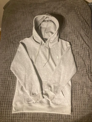 Ralph Lauren hoodie - Säljer en riktigt snygg grå Ralph Lauren hoodie i nyskick. Storlek M men passar även S. Priset går att diskutera,lägg ett bud!
