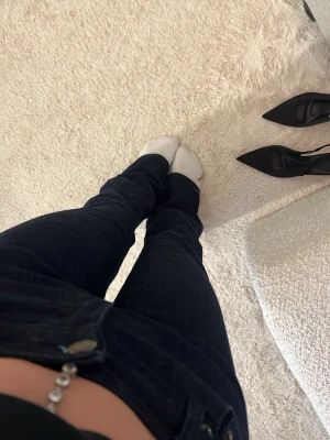 Mörkblå utsvängda jeans lågmidja - Säljer ett par mörkblå jeans med utsvängd passform och medel midja. Klassisk femficksmodell med knapp och dragkedja framtill. Perfekta till en avslappnad och trendig look.