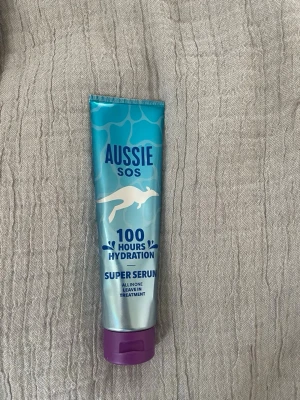 Aussie SOS Super Serum 100h Hydration - Aussie SOS Super Serum är en leave-in behandling för håret som ger intensiv återfuktning i upp till 100 timmar. Kommer i en blå och silver tub med lila lock och rymmer 160 ml. Perfekt för dig som vill ha mjukt och återfuktat hår. Använt några gånger.