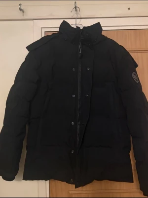 Canada Goose wyndham  - Säljer en svart Canada Goose Wyndham i storlek M. Jackan är i mycket fint skick, nästan som ny och väldigt varm – perfekt för vintern.  Pälsen till huvan följer också med om man vill ha den.  Pris kan diskuteras vid snabb affär. Vill du ha fler bilder kan jag skicka det också. Hör av dig vid intresse!