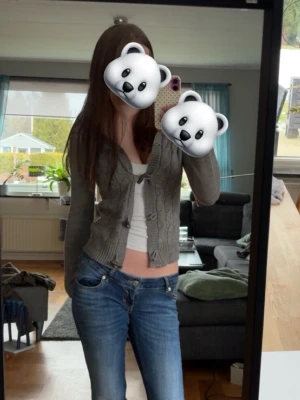 Grå Cardigan/ Kofta Vintage - Säljer en jättefin grå stickad cardigan med kabelstickat mönster. Den är figursydd och ger en smickrande silhuett 🤍 Perfekt att bära både öppen eller knäppt!  ✨ Mjuk och skön stickad kvalitet ✨ Kabelstickat mönster framtill ✨ Djup V-ringning ✨ Dekorativa knappar framtill ✨ Fint skick  Superfin till jeans för en vardagslook eller över ett linne för en mer uppklädd stil.  Storlek: S Märke: calliope   Hör av dig vid frågor 💕