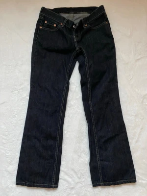 Lågmidjade Levis jeans - Inga defekter, snyggaste tvätten. Midja 32cm rakt över och innerbenslängd 70cm. Lätt utsvängning nertill