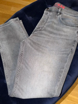 Ljusgrå raka jeans från 1334 - Snygga ljusgrå jeans från 1334 med rak passform och klassisk femficksdesign. Jeansen har en diskret tvättad look och är tillverkade i mjukt denimtyg. Perfekta för en avslappnad och trendig stil.