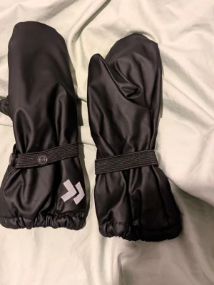 Svarta tumvantar med reflexdetalj - Regnvantar, ej använda. Stl4/6 år.