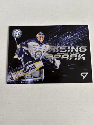 Hockeykort Marcus Gidlof Rising Spark - Unikt hockeykort från Sportzoo-serien 'Rising Spark' med Marcus Gidlof från Leksands IF. Kortet har en cool design med blå, vit och gul färg och SHL 50-årslogga. Perfekt för samlare av svenska hockeykort och SHL-relaterade prylar. Hör av er vad ni kan tänka er för pris!