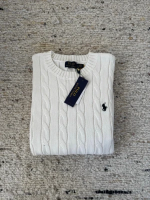Vit Ralph Lauren Sweater - Vit stickad Sweater från Polo Ralph Lauren, QR-kod finns. Kommer med prislapp och RL zipbag. 