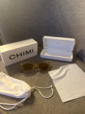 Beige solglasögon från CHIMI - Snygga solglasögon från CHIMI i transparent beige med fyrkantig form. Kommer med originaletui, putsduk och tygpåse. Perfekta för dig som vill ha en clean och modern look i sommar. 💕