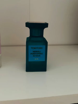 Tom Ford Neroli Portofino Acqua 50 ml - Tom Ford Neroli Portofino Acqua är en lyxig parfym i en stilren, turkosblå glasflaska med fyrkantig form och elegant lock. Doften är fräsch och citrusaktig, inspirerad av Medelhavet. Flaskan har en modern design och känns exklusiv i handen. Ingen box.