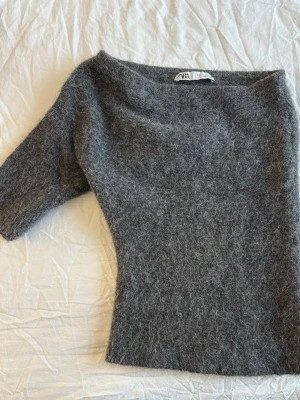Grå asymmetrisk stickad - Zara - Säljer en slutsåld asymmetrisk stickad tröja från Zara i storlek S. Den är i mycket fint skick och knappt använda Nypris: 499 kr
