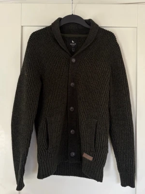 Mörkgrön stickad kofta från Broken - Säljer en mörkgrön stickad kofta från Broken. Snygg över skjorta eller t-shirt 