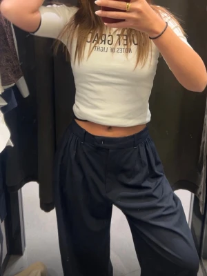  mörkblåa byxor med hög midja - Hej! Säljer ett par mörkblåa byxor med lös passform och hög midja. Byxorna har bred linning och veck framtill för en trendig look. Perfekta för dig som gillar en avslappnad men ändå stilren stil.