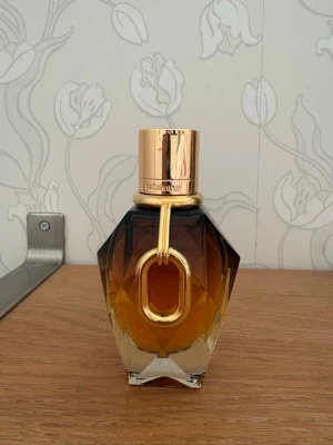 Rabanne Million Gold parfym 50 ml - Den här produkten är en parfymflaska från Rabanne, specifikt Million Gold for Her. Doften beskrivs som en grand floral med noter av rose, vita blommor och mineralmysk. 