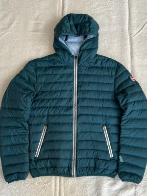 Grön Colmar dunjacka i storlek S - Grön Colmar dunjacka med vit/grå dragkedjor Några defekter Storlek 46/motsvarar S, liten M Hör av er vid frågor!