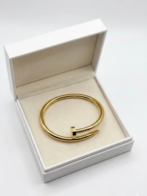 18K guld pläterade armband  - Snyggt armband i guldfärgad metall med unik spikformad design. Stilren och modern accessoar som sticker ut och passar perfekt för dig som gillar edgy detaljer. Kommer i en elegant ask.