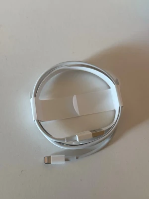 Vit Lightning till USB-kabel Apple - Helt ny. Säljer en vit Lightning till USB-kabel från Apple. Perfekt för laddning och synkronisering av iPhone eller iPad. Kabeln är rund och har en slimmad design med klassisk Apple-look. Tillverkad i tålig plast med metallkontakter.