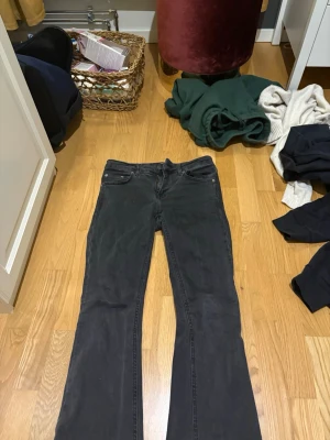 Svarta bootcut jeans - Snygga svarta bootcut jeans med klassisk femficksmodell och normal midja. Jeansen har en lätt utsvängd passform nedtill och är tillverkade i ett mjukt denimtyg med stretch för extra komfort. Perfekta till en avslappnad vardagslook.
