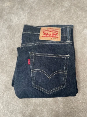 Levi's 511 mörkblå jeans - Säljer ett par klassiska Levi's 511 jeans i mörkblå denim med raka ben och snygga kontrastsömmar. Superbra skick! Kolla gärna in mina andra annonser!🥰