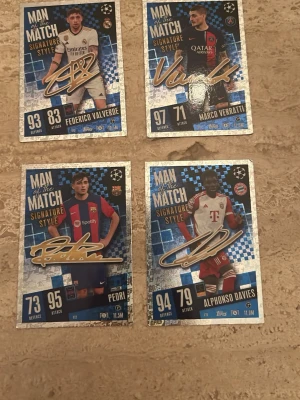 Match Attax Man of the Match kort - Fyra Match Attax Man of the Match Signature Style samlarkort från Topps med spelare från Real Madrid, PSG, Barcelona och Bayern München. Kort i blå, guld och vit design med klubbemblem, autograftryck och spelardata. Perfekt för dig som gillar fotboll och samlarkort.