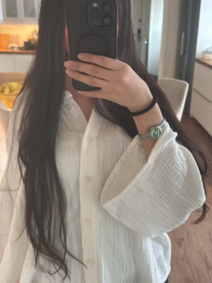 Vit bomullsskjorta med vida ärmar - Säljer en vit skjorta i bomull med knappar framtill och breda, luftiga ärmar. Skjortan har en loose passform och är tillverkad i ett strukturerat tyg som känns mjukt och bekvämt. Perfekt för dig som gillar en enkel och stilren look. Jag personligen bär på xs men den är i strl xl för att de den loose passformen. 