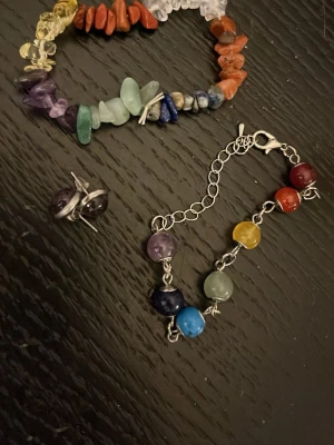 Armband och örhängen med ädelstenar - Unikt armband med ädelstenar i flera färger som lila, blå, grön, gul, röd och orange. Helt nya och oanvända.