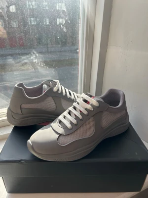 Gråa Prada Cups - Ett par knappt använda Prada Cups i matte. Säljer eftersom dem sitter lite trångt på mig. Men dem är nästa helt oanvänd, defekter syns i annonsen. Du får med box,påse ect. Har du några mer frågor är det bara att skriva🌟