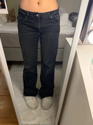 Svarta raka jeans med låg midja  - Säljer ett par svarta jeans med raka ben och låg midja. Jeansen har klassiska fem fickor och kontrastsömmar. Perfekta till en avslappnad och trendig look. Materialet är denim i bomull. Jag har vikt upp de då det är för långa. 
