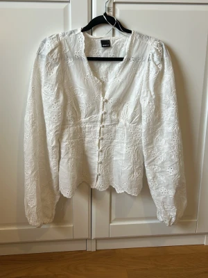 Vit broderad blus med knappar - Supersöt populär vit blus från Gina Tricot med broderade blommor och dekorativa knappar framtill. Slutsåld 💫💫