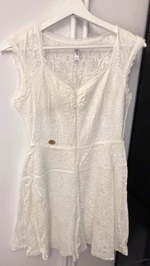 Vit studentklänning i strl M - Säljer en söt vit/beige spetsklänning från Bubbleroom i strl M. Klänningen är kort, v-ringad och har fina spetsdetaljer. Använd en gång och har inga defekter. Perfekt inför studenten eller sommaren. Nypris är 600kr. Pris går att diskutera vid snabb affär😊