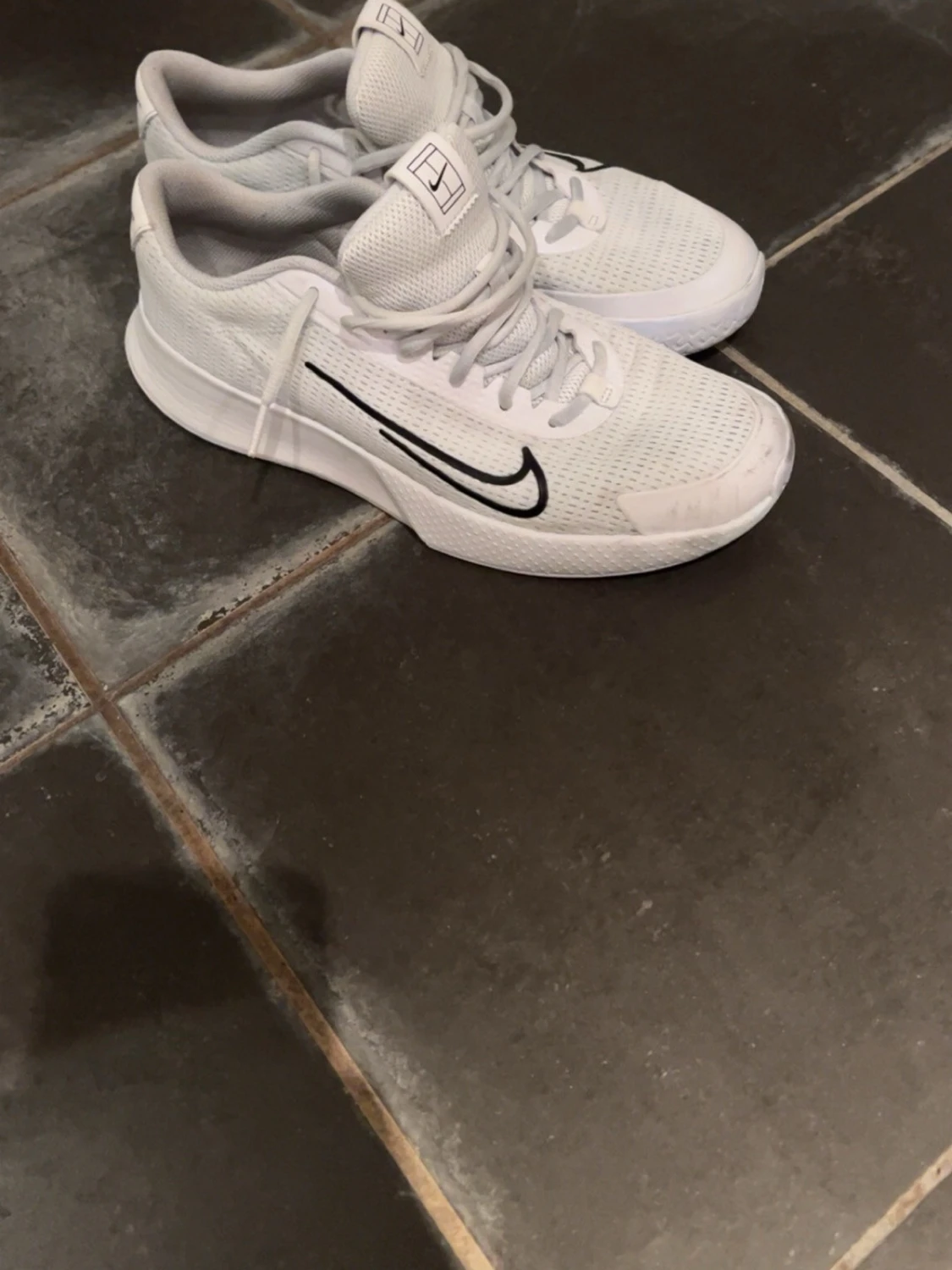 Vita Nike inneskor med svart swoosh