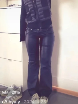 Svarta bootcut jeans från ONLY - Säljer ett par svarta bootcut jeans från ONLY i storlek S/32. Jeansen har en glansig finish, klassisk femficksmodell och normalhög midja. Snygg passform som sitter tight upptill och släpper ut vid benen. Perfekta för en trendig och cool look.
