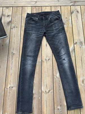 Svarta skinny jeans från Dondup - Snygga svarta skinny jeans från Dondup med slitningar och tvättad look. Jeansen har klassisk femficksmodell, normal midja och smal passform. Tillverkade i stretchigt denim för extra komfort. Perfekta för en trendig och avslappnad stil.