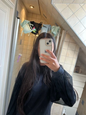 Svart topp med meshärmar - Säljer en svart tröja med långa, vida meshärmar som ger en snygg och trendig look. Det står 158-164 men passar även mig som är 172 bra. Tröjan har rund halsringning och är gjord i ett mjukt material med transparenta ärmar i mesh. Kan användas som finkläder. 