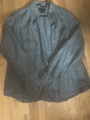 Grön linneskjorta Massimo dutti - Snygg grön skjorta i linne med klassisk krage och knäppning framtill från Massimo dutti. Skjortan har lång ärm och en bröstficka, perfekt för en avslappnad men stilren look. Aldrig använd, enbart testad!