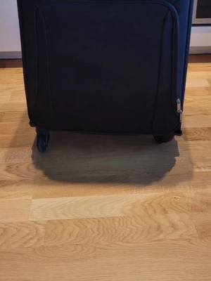 Svart mjuk resväska med hjul - Praktisk svart resväska med fyra hjul och dragkedja. Väskan har ett mjukt yttertyg och rymligt inre med flera fack för enkel packning. Perfekt för weekendresor eller som kabinväska. Enkel att rulla och smidig att ta med sig.