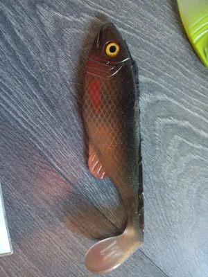 Mjukplastfisk för fiske - En realistisk mjukplastfisk i mörkbrun och röd färg med gula ögon och detaljerade fenor. Perfekt som bete till gäddfiske eller andra rovfiskar. Fisken har en flexibel kropp och paddelstjärt för naturlig rörelse i vattnet. Hemma gjutna .