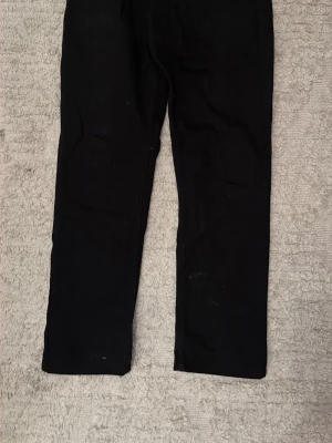 Levis jeans 501 - Svarta jeans med rak passform och klassisk femficksdesign. Jeansen har normal midja och är tillverkade i ett denimtyg som ger en stilren look. Perfekta för dig som gillar en enkel och tidlös stil. Skick 9/10 använda fåtal gånger. Storlek W31 L32