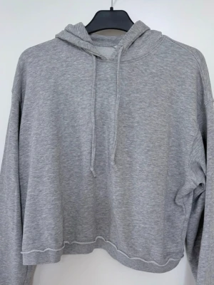 Snygg Croppad hoodie med råa kanter, från Monki! - En hoodie med croppad passform och råa, rullade kanter nertill, och vid ärmsluten. Justerbar huva med dragsko, sänkta axlar och en kortare längd. Axelbredd 51, längd 52 Använd sparsamt! Inga skavanker! Säljer en blå också.  Nypris 349 kr 