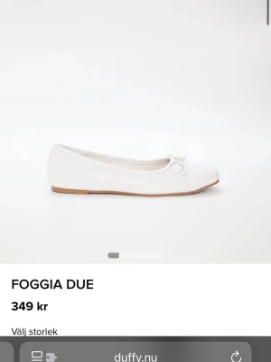 Vita ballerinaskor från Duffy - Stilrena vita ballerinaskor från Duffy med rund tå och dekorativ rosett framtill. Heter Foggia Due. Storlek 36. Aldrig använda. Köpta ifrån Ellos.