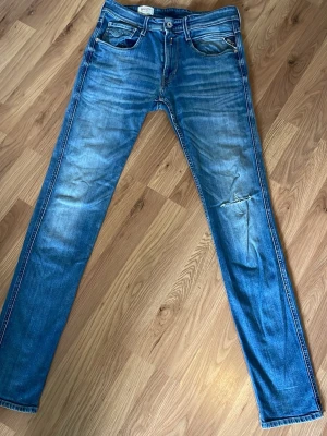 Replay anbass jeans - Säljer ett par blå anbass jeans från Replay med snyggt slitna detaljer. Väldigt sköna och sitter bra. Säljer på grund av att dem inte används längre