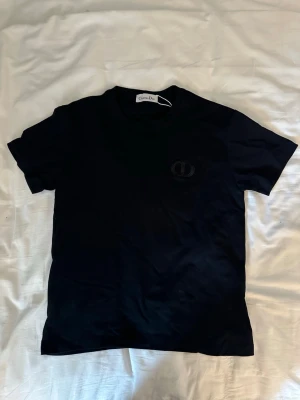 CD t shirt - Snygg svart t-shirt  med diskret broderad logga på bröstet. Klassisk rund halsringning och korta ärmar. Du vet varför den är så billig! Kontakta gärna mig om du är intresserad, pris är inte hugget i sten! Är i storlek S men passar xs bättre
