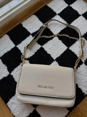 Beige axelremsväska Michael Kors - Köpt i Grekland! Minimal fläck på insidan, försökte ta kort men de syns typ inte ens!