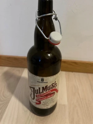 Gammaldags Julmust 1L Nyckelbryggerier - Gammaldags Julmust från Norrbotten, producerad i Älvsbyn av Nyckelbryggerier. Flaskan rymmer 1 liter och har en klassisk etikett i vitt och rött samt en bygelkork. Tom och rengjord. Perfekt inredningsdetalj. 