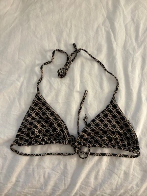 Mönstrad bikiniöverdel  - Triangelformad bikiniöverdel med kedjemönster och knyte i både nacke & rygg. Lappen är bortklippt men från H&M i storlek XS(passar S med liten byst)💕använd 1 gång och självklart tvättad