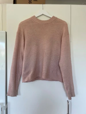 Ljusrosa stickad tröja från H&M - Mysig ljusrosa stickad tröja från H&M med rund halsringning och ribbade muddar vid ärmslut och nederkant. 