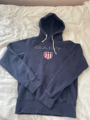 Marinblå GANT hoodie - Säljer en marinblå GANT hoodie i mycket bra skick!! storleken står inte me men skulle säga typ Xs-S💕
