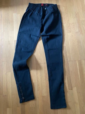 Svarta jeansleggings Vero Moda  - Säljer ett par svarta jeansleggings med stretch. smal passform och dragkedjor vid bensluten. De har resår i midjan 