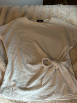 Vit topp med knyt i midjan - Jättesnygg vit stickad topp från Zara. 