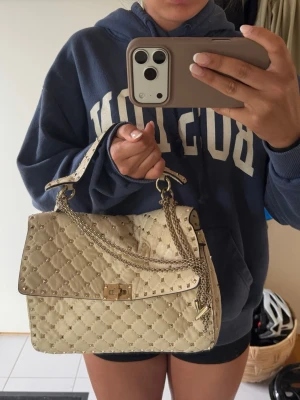 Valentino väska  - Valentino garavani väska, äkthetsbevis finns och väskan är i den stora modellen 💕💕beige/vit färg med silvriga nitar